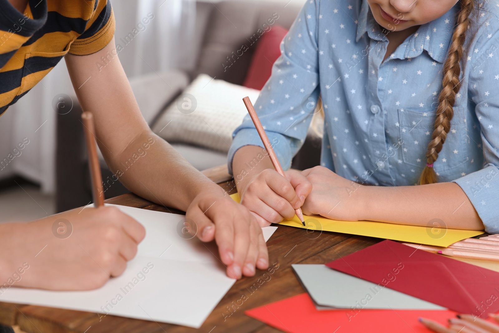 Photo of Children making beautiful greeting cards at table indoors, closeup