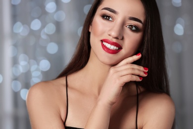Photo of Beautiful woman with stylish nail polish against blurred lights