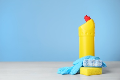 Photo of Bottle of cleaning product and supplies on light table. Space for text