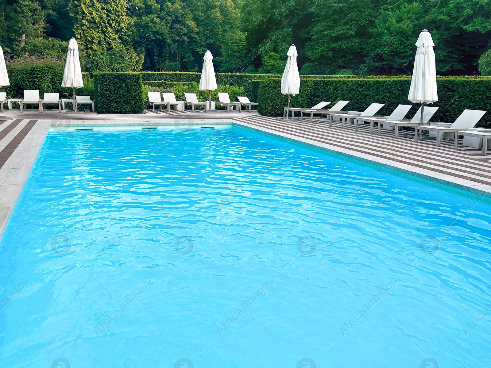 Photo of Outdoor swimming pool in luxury hotel on sunny summer day. Time for relax