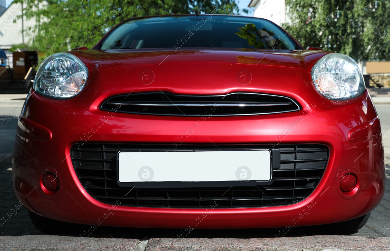 Photo of Red car with vehicle registration plate outdoors