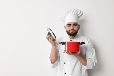 Photo of Professional chef with cooking pot on white background