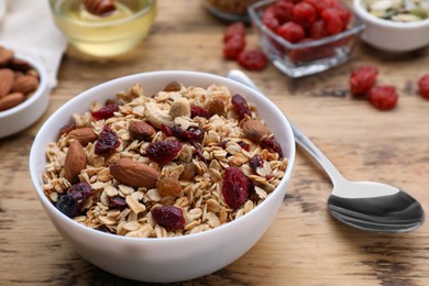 Tasty granola served with nuts and dry fruits on wooden table, closeup