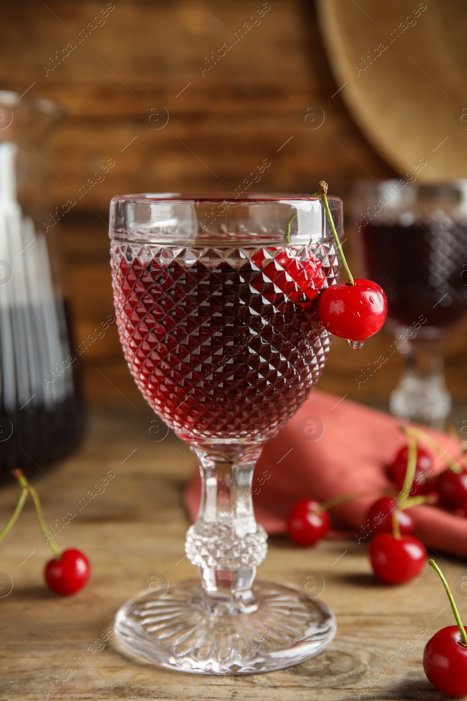 Photo of Delicious cherry wine with ripe juicy berries on wooden table