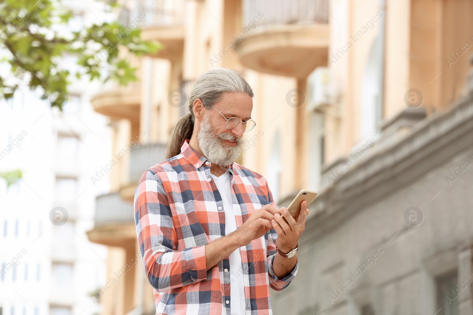 Photo of Handsome mature man with mobile phone, outdoors