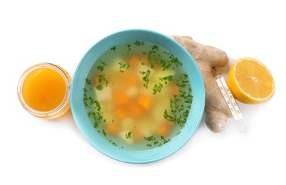 Bowl of fresh homemade soup to cure flu, lemon, ginger and honey on white background, top view