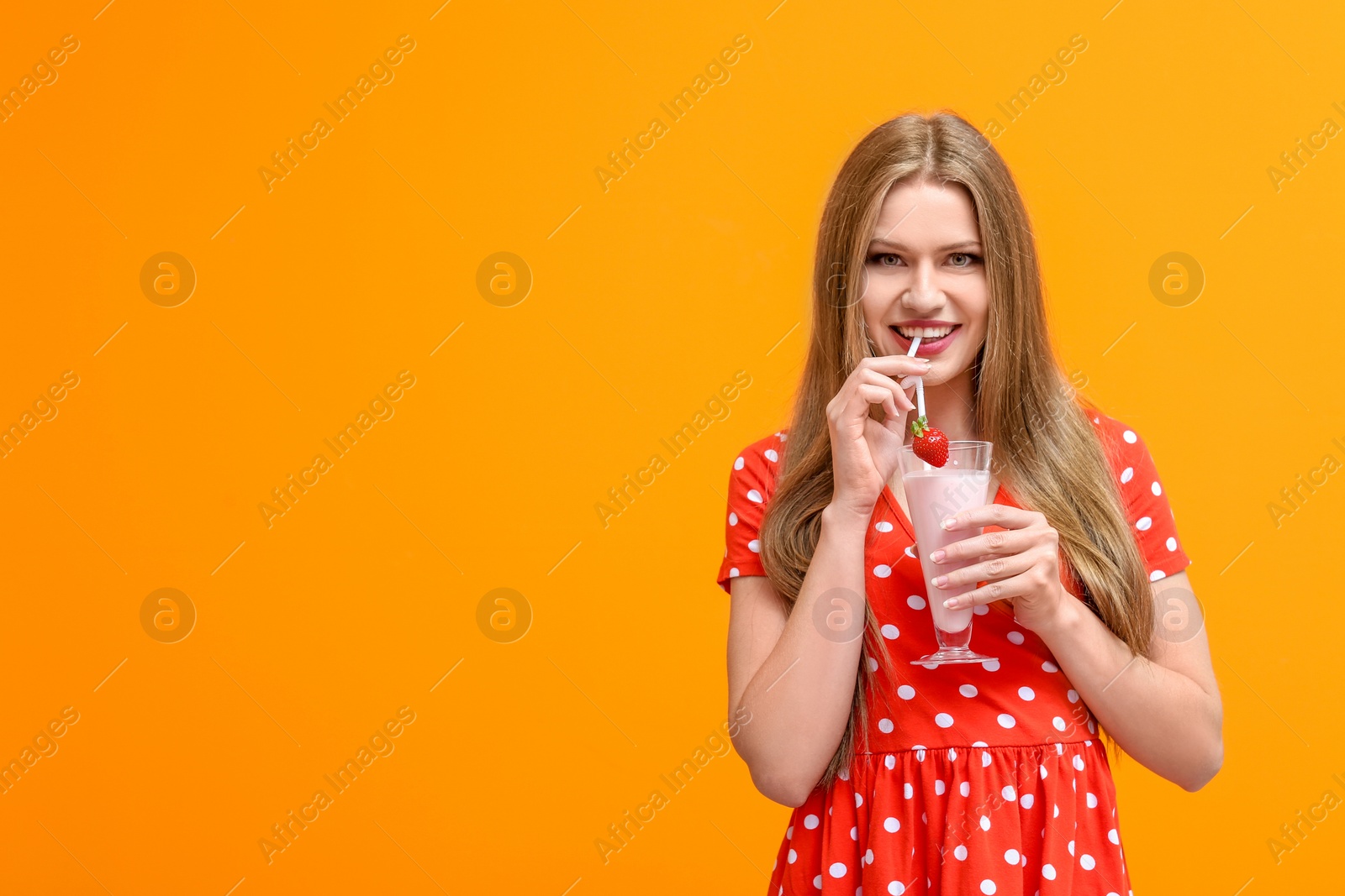 Photo of Young woman with glass of delicious milk shake on color background