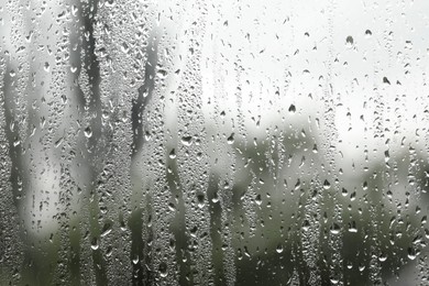 Photo of Window glass with raindrops as background, closeup