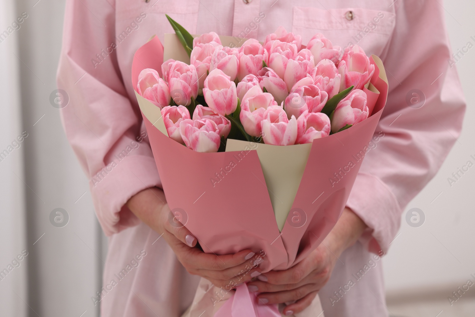 Photo of Woman with bouquet of beautiful fresh tulips on blurred background, closeup