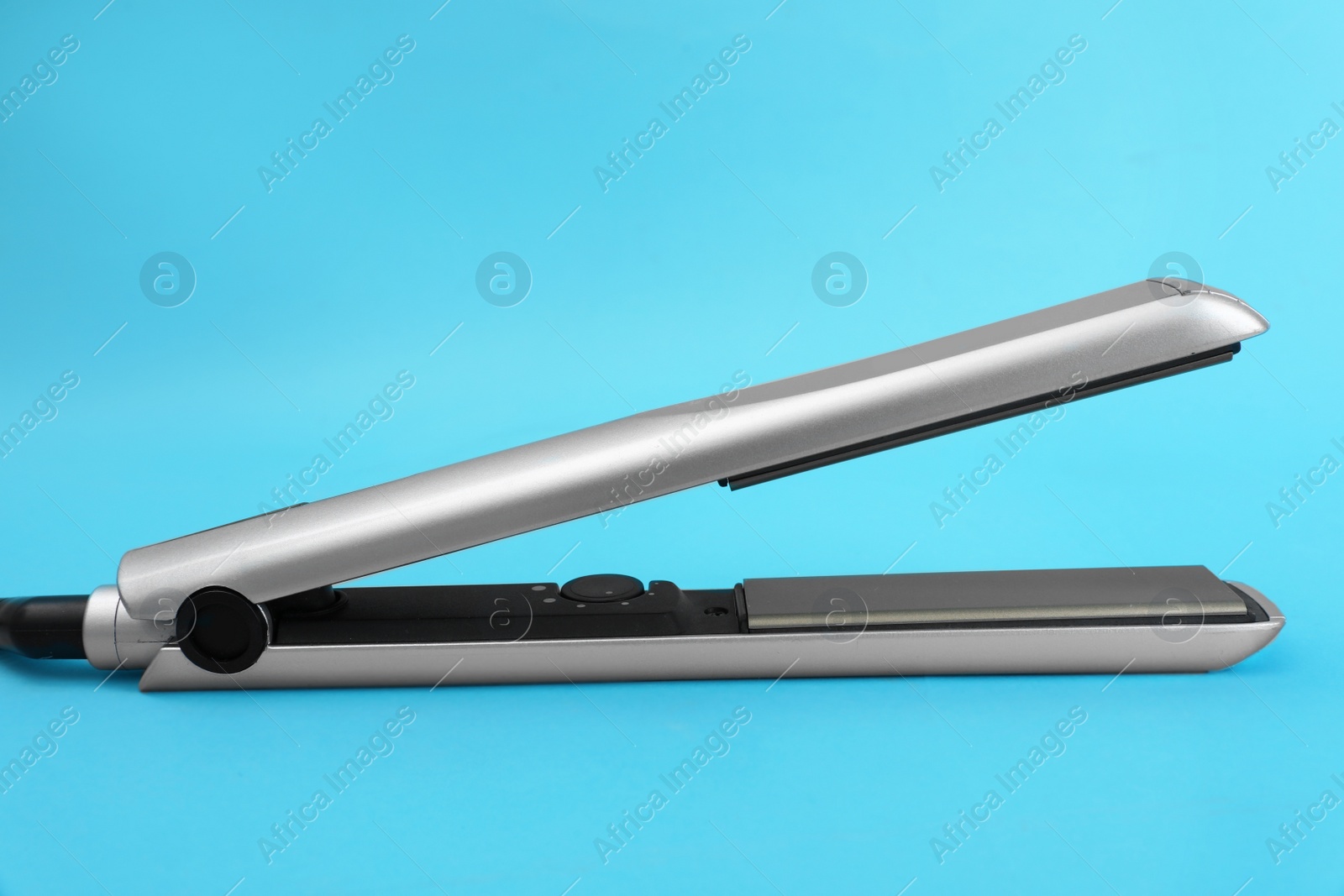 Photo of Modern hair iron for straightening on color background