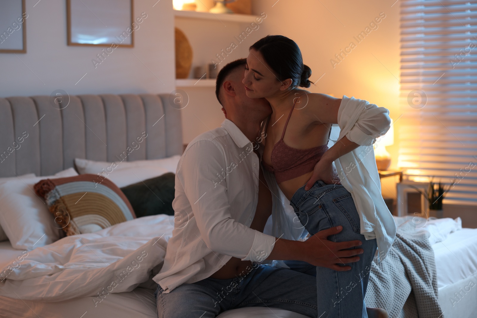 Photo of Passionate couple enjoying each other in bedroom at night