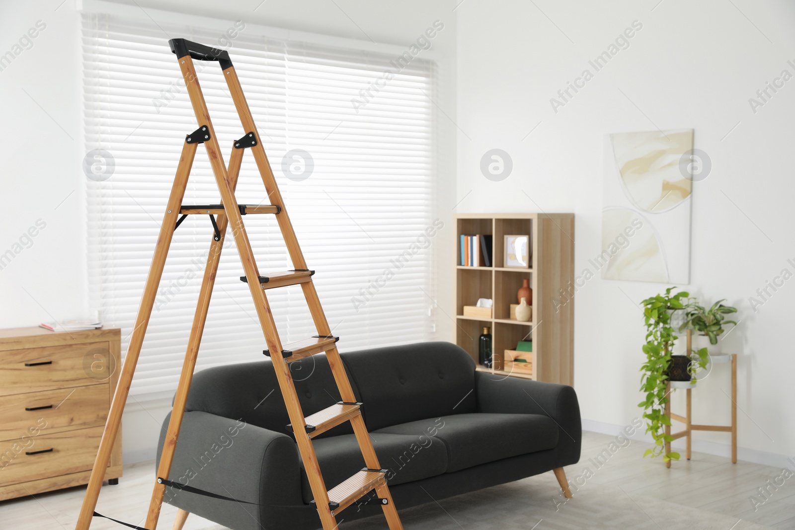 Photo of Wooden folding ladder in stylish living room