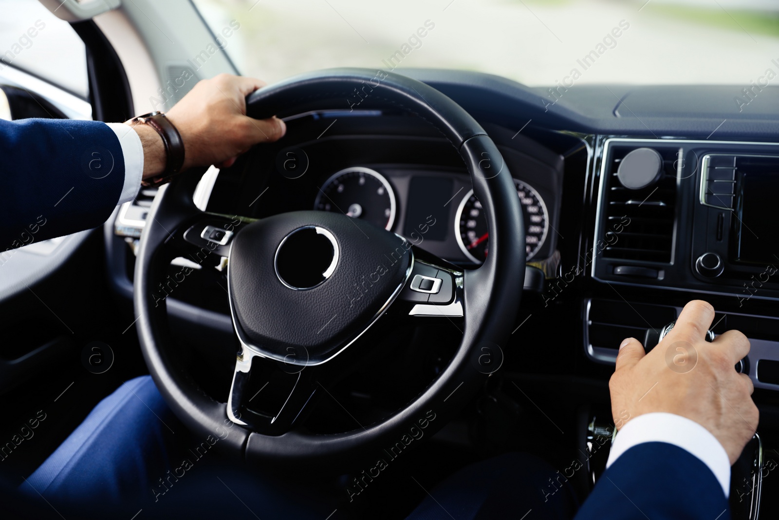 Photo of Man driving his car, closeup view of hands on steering wheel