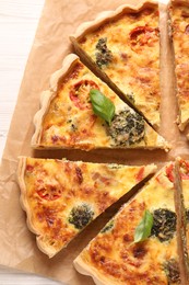 Photo of Delicious homemade vegetable quiche on parchment paper, top view