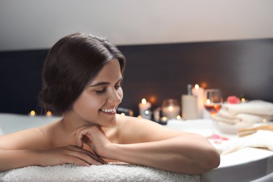 Photo of Happy beautiful woman taking bath indoors. Romantic atmosphere
