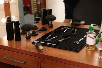 Set of hairdressing tools on wooden table in salon