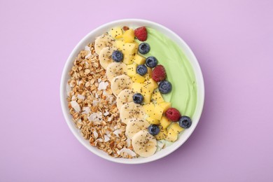 Photo of Tasty matcha smoothie bowl served with fresh fruits and oatmeal on violet background, top view. Healthy breakfast