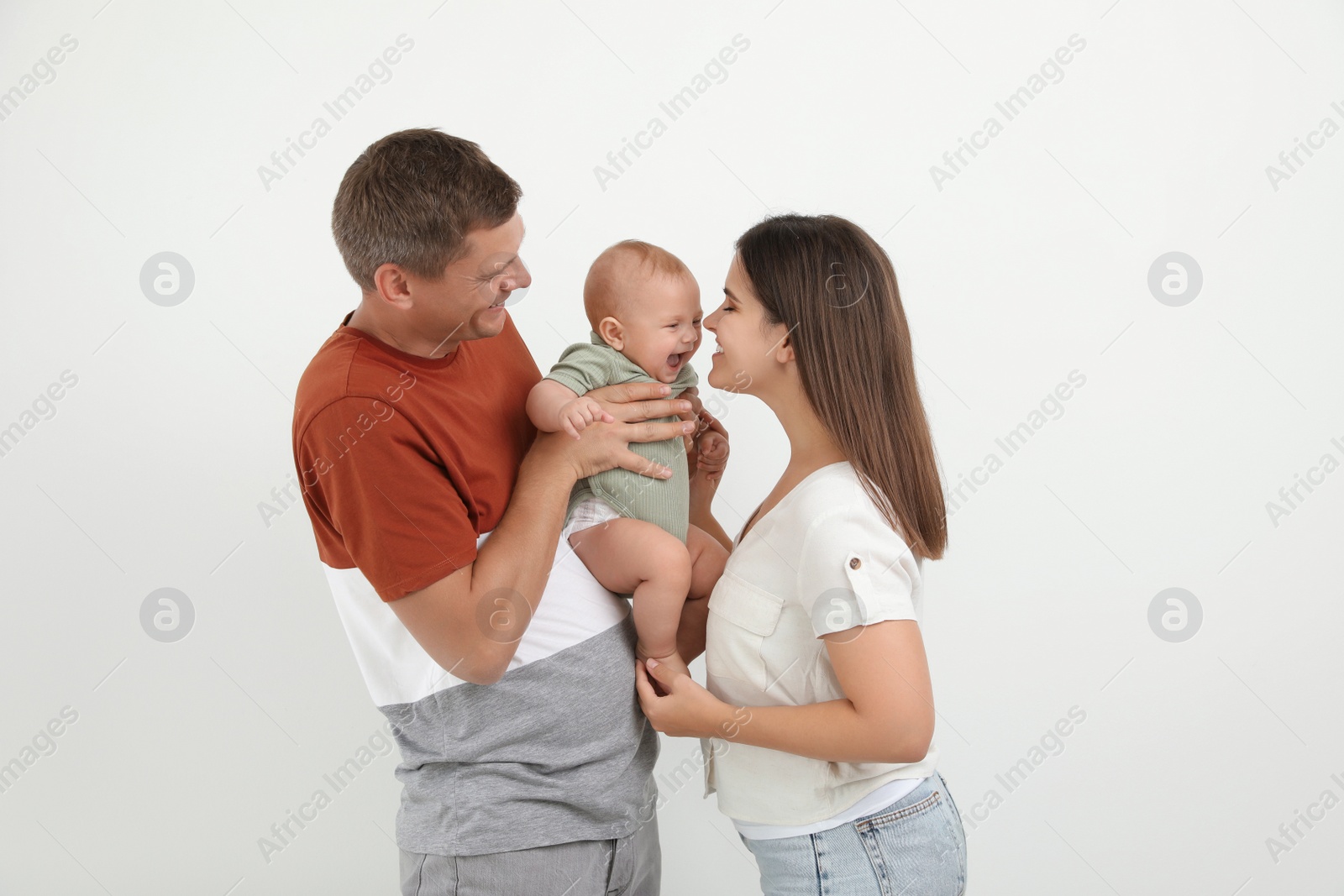 Photo of Portrait of happy family with their cute baby on white background