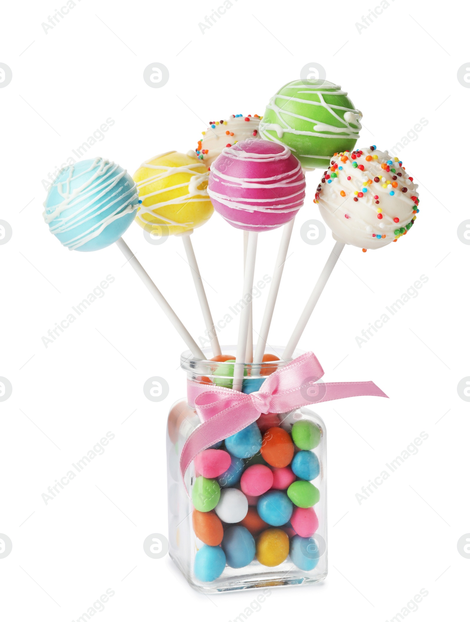 Photo of Delicious colorful cake pops in glass with candies on white background