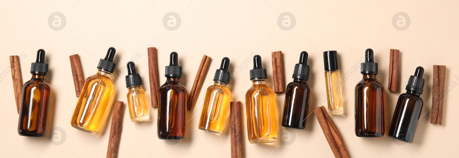 Photo of Flat lay composition with cinnamon essential oil on beige background