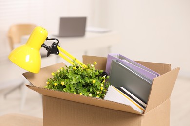 Photo of Unemployment problem. Box with worker's personal belongings in office