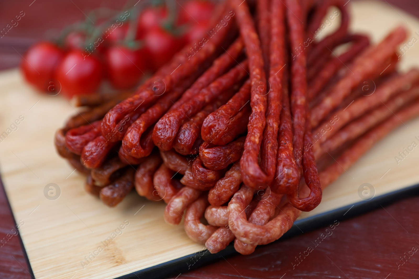 Photo of Tasty dry cured sausages (kabanosy) on wooden table, closeup