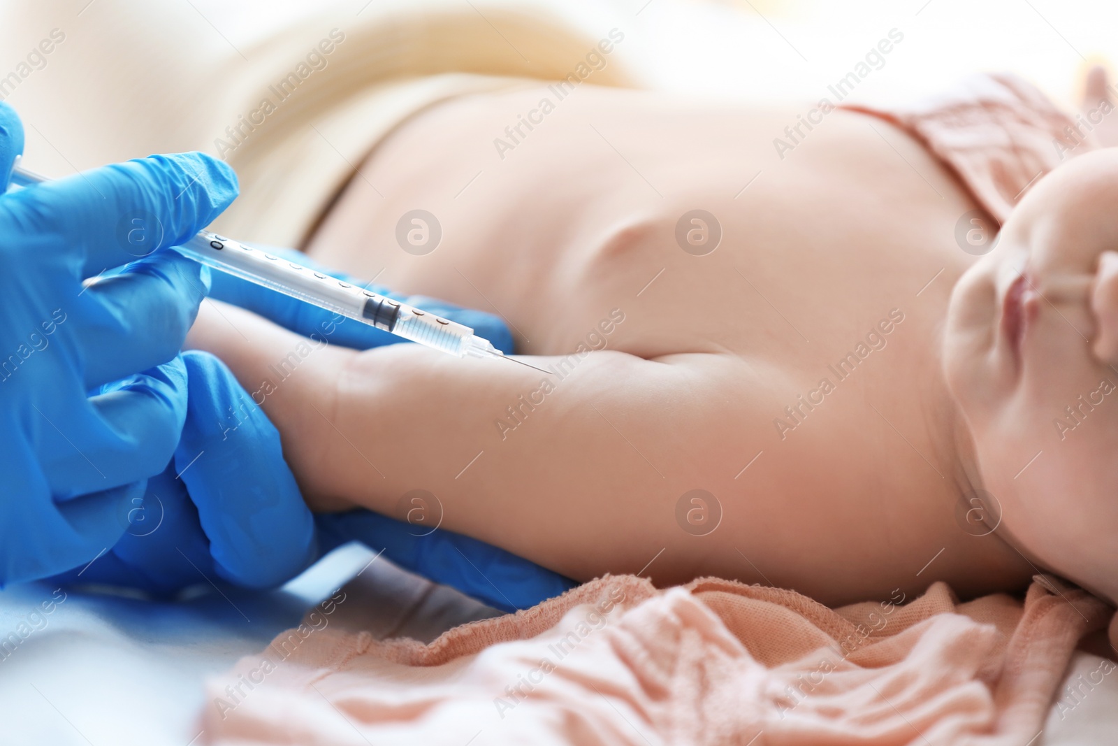 Photo of Doctor vaccinating baby in clinic, closeup