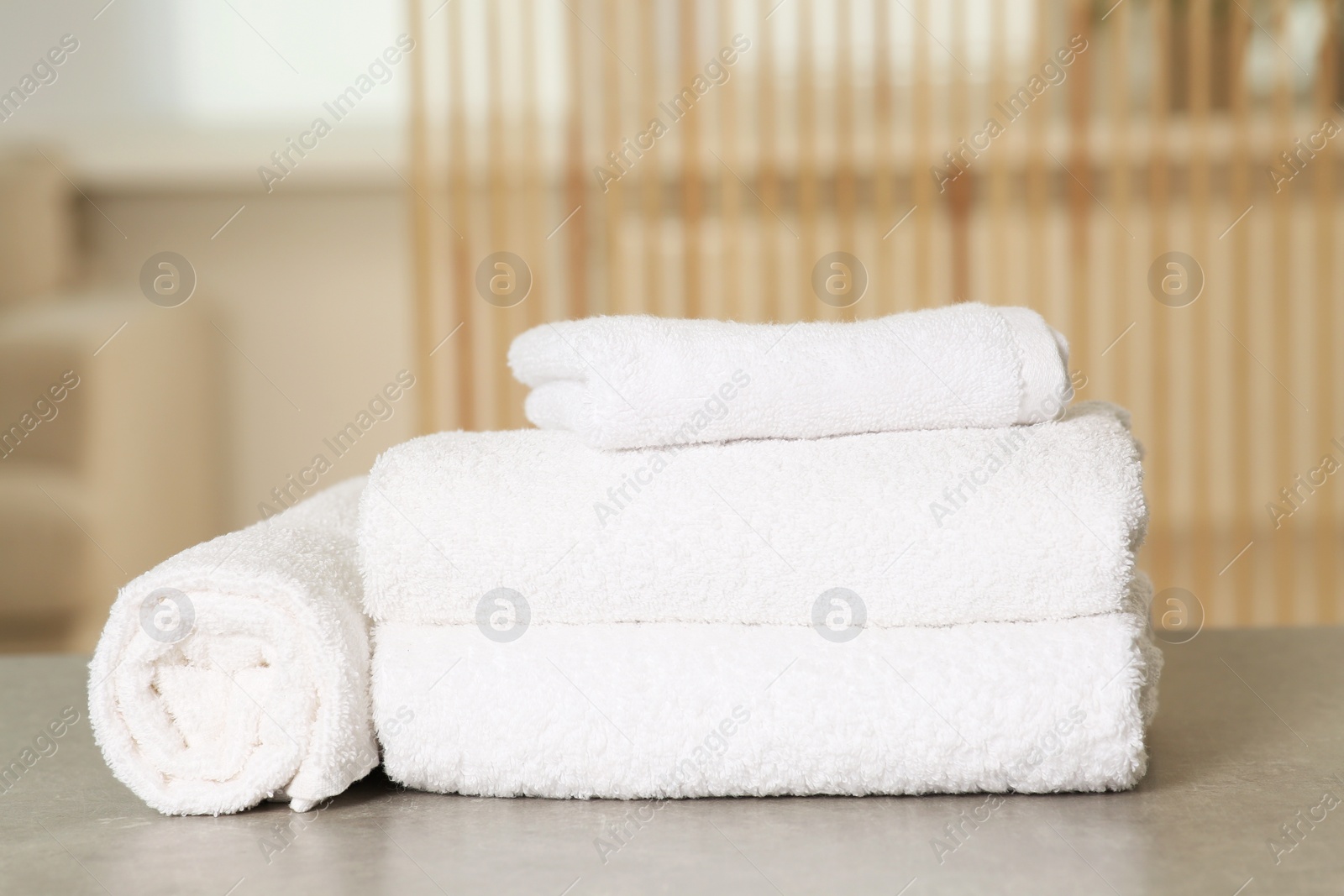 Photo of Soft folded terry towels on light gray table indoors