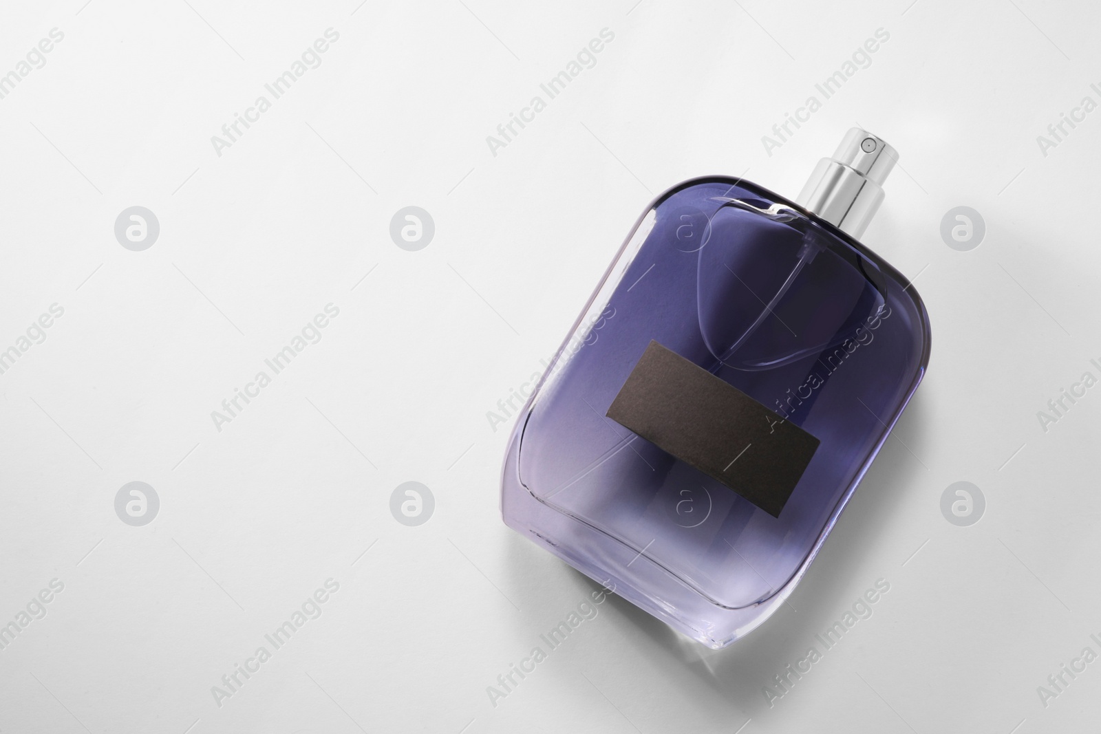 Photo of Luxury men`s perfume in bottle on white background, top view. Space for text