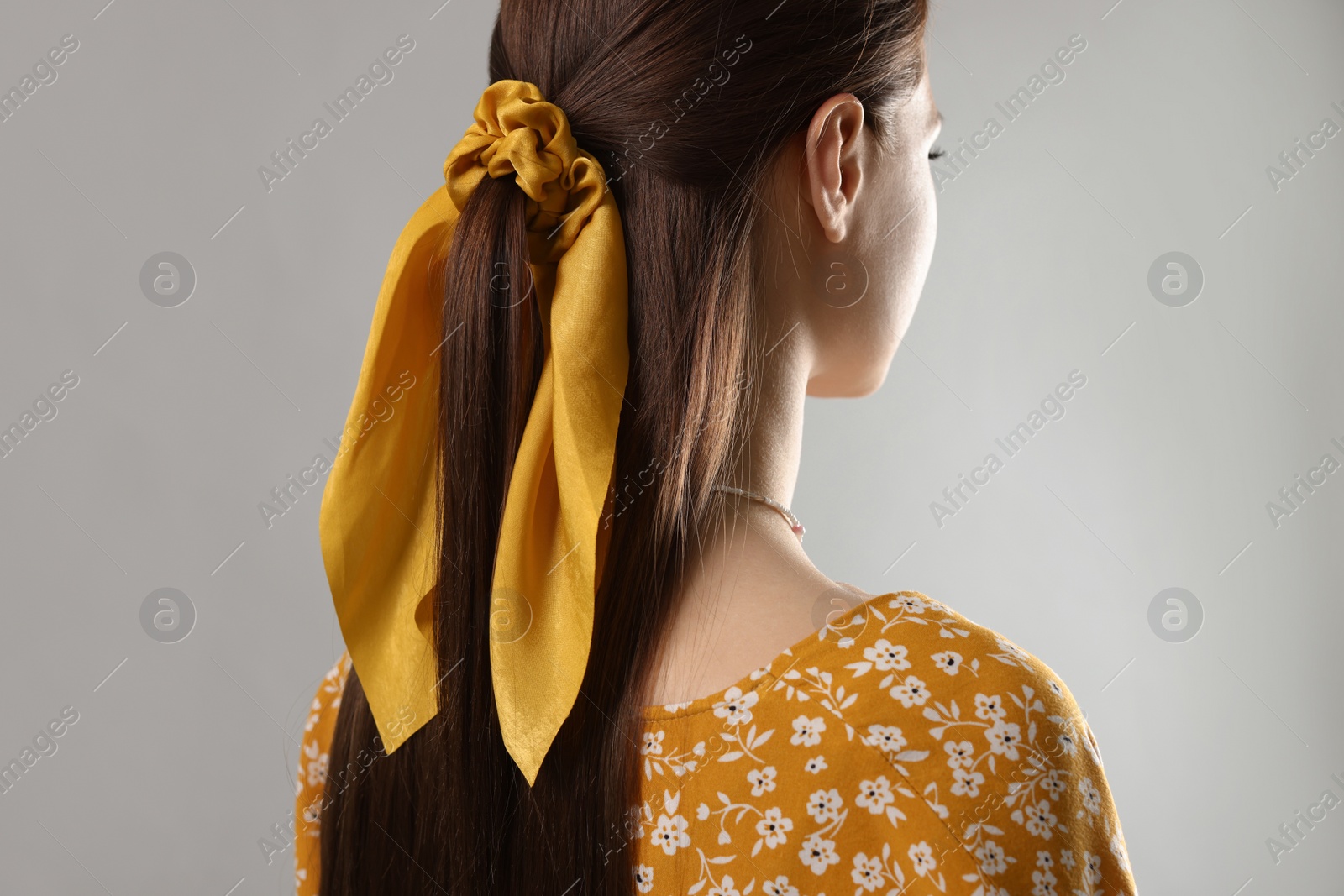 Photo of Woman with stylish yellow bandana on light grey background