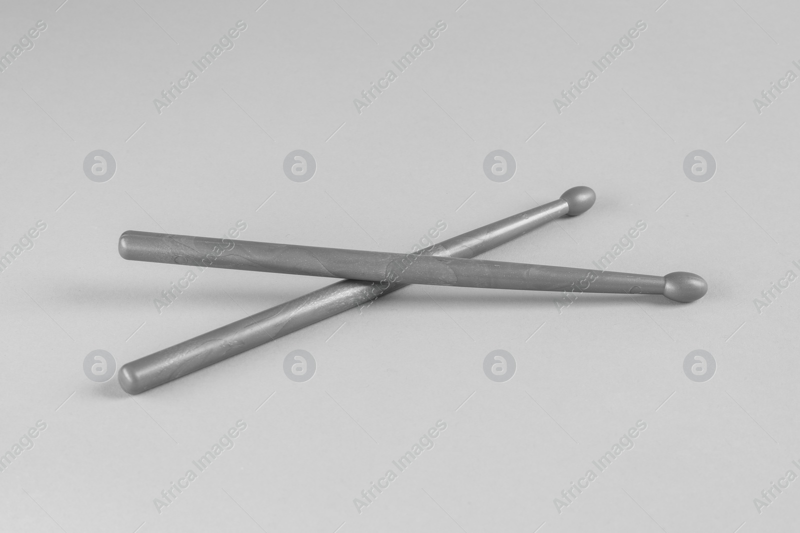 Photo of Two gray drum sticks on light background