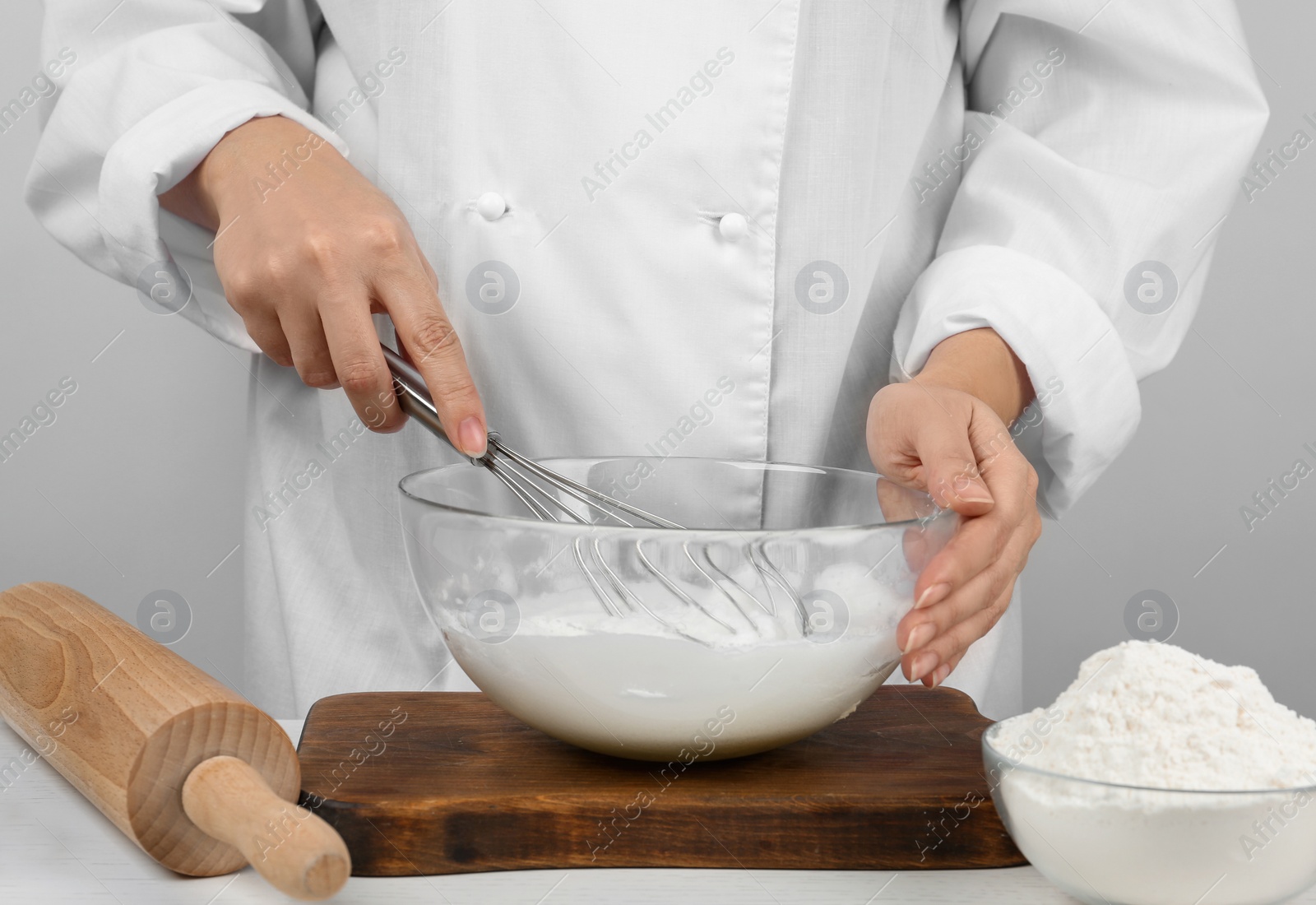 Photo of Woman whipping egg whites at wooden table, closeup. Baking pie