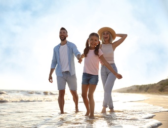 Photo of Happy family on sandy beach near sea
