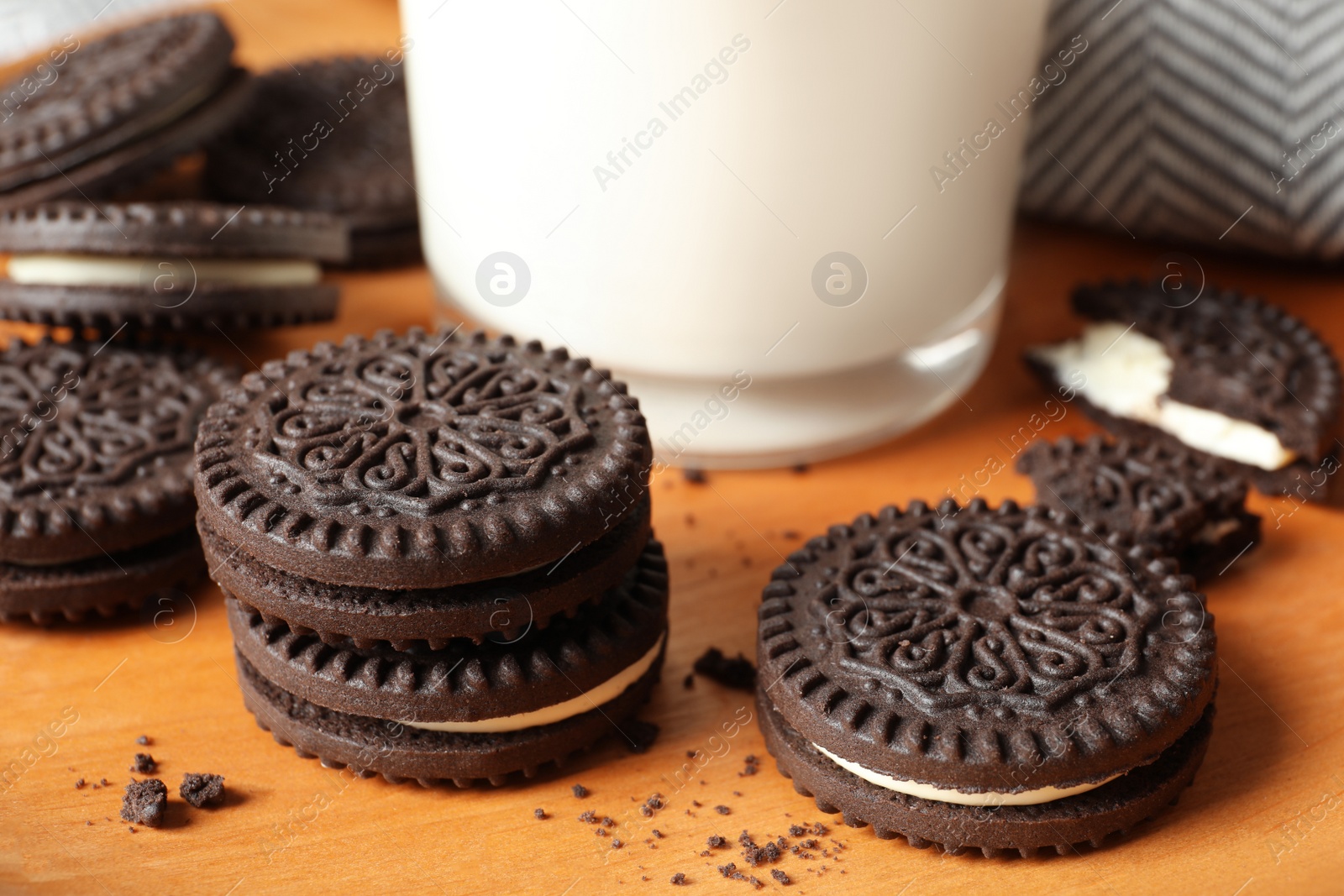 Photo of Plate with chocolate sandwich cookies and milk, closeup