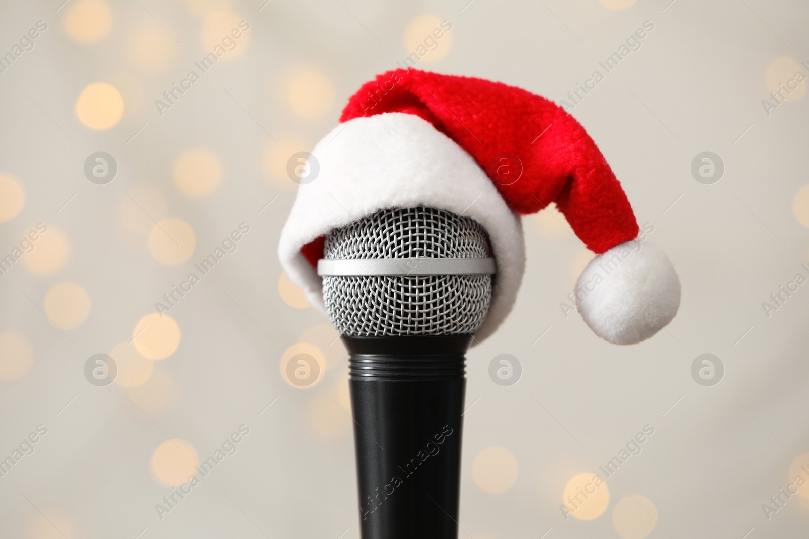 Photo of Microphone with Santa hat against blurred lights. Christmas music