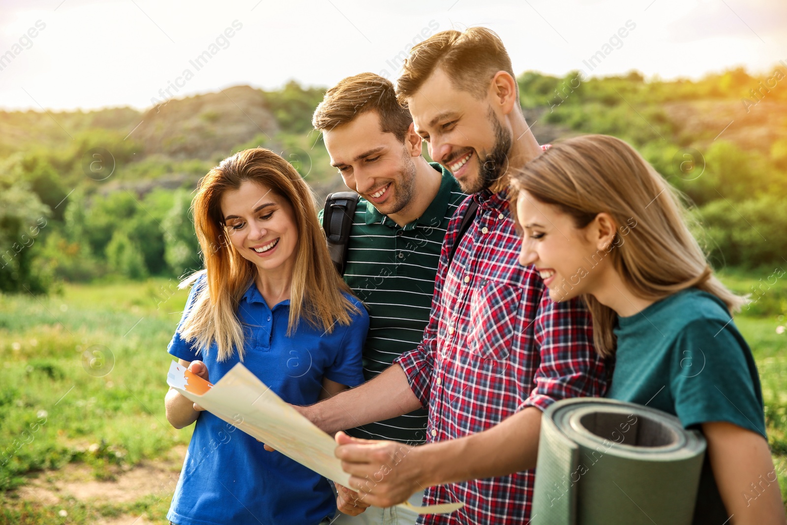 Photo of Young people exploring map in wilderness. Camping season