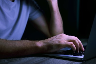 Photo of Man using computer at night, closeup. Internet addiction