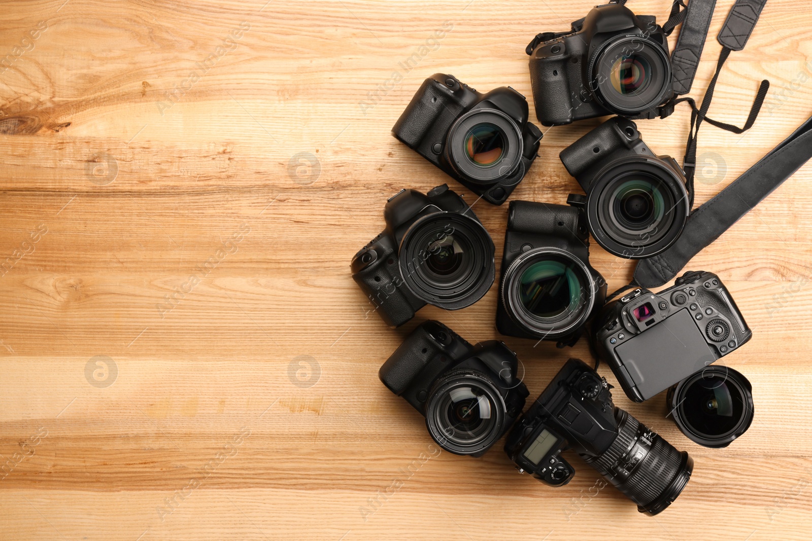 Photo of Modern different cameras on wooden table, flat lay. Space for text