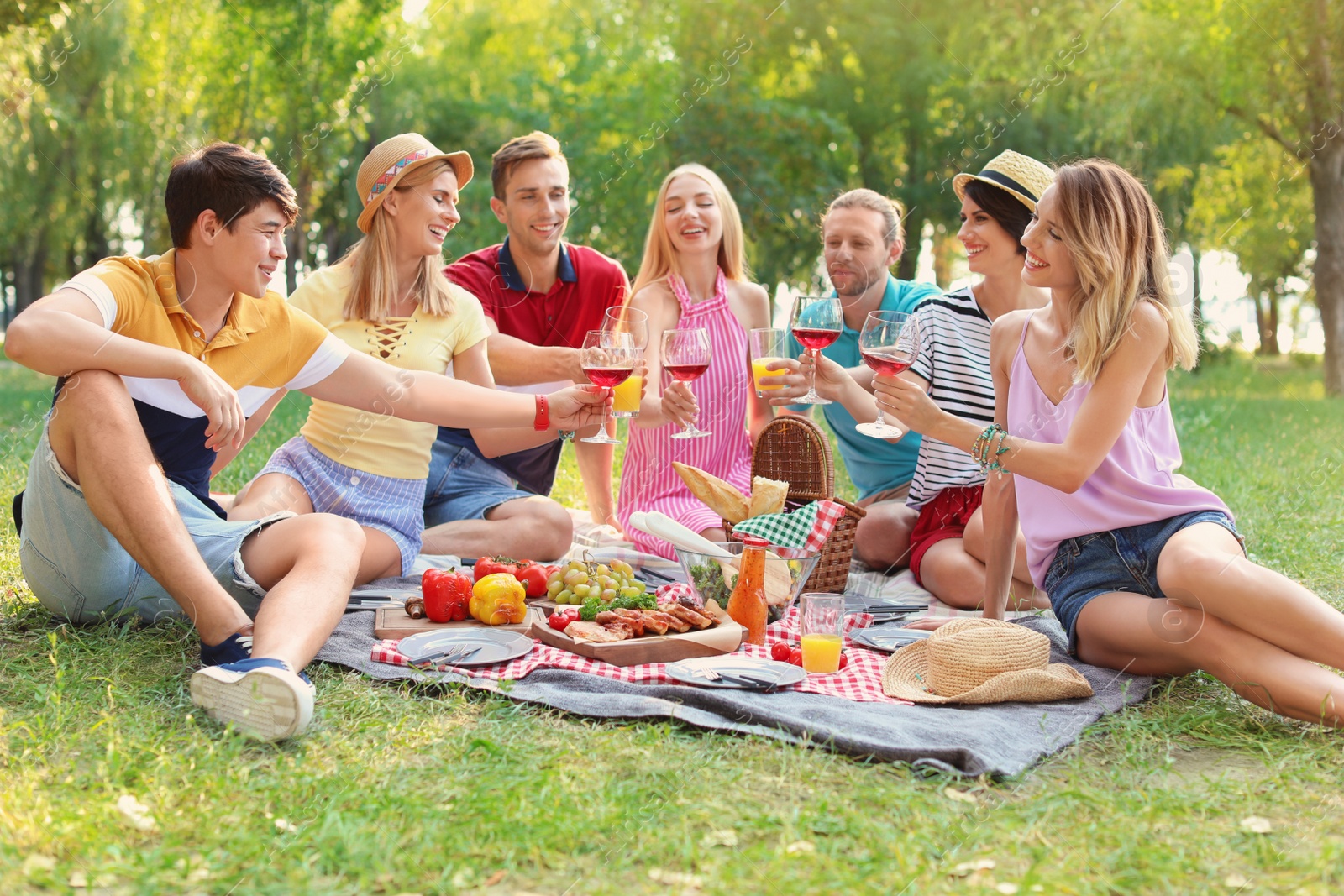 Photo of Happy friends having picnic in park on sunny day