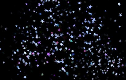 Image of Many beautiful shimmering stars on black background