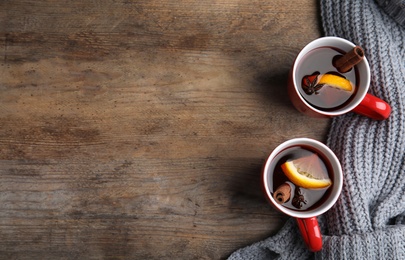 Photo of Flat lay composition with cups of hot winter drink on wooden table. Space for text