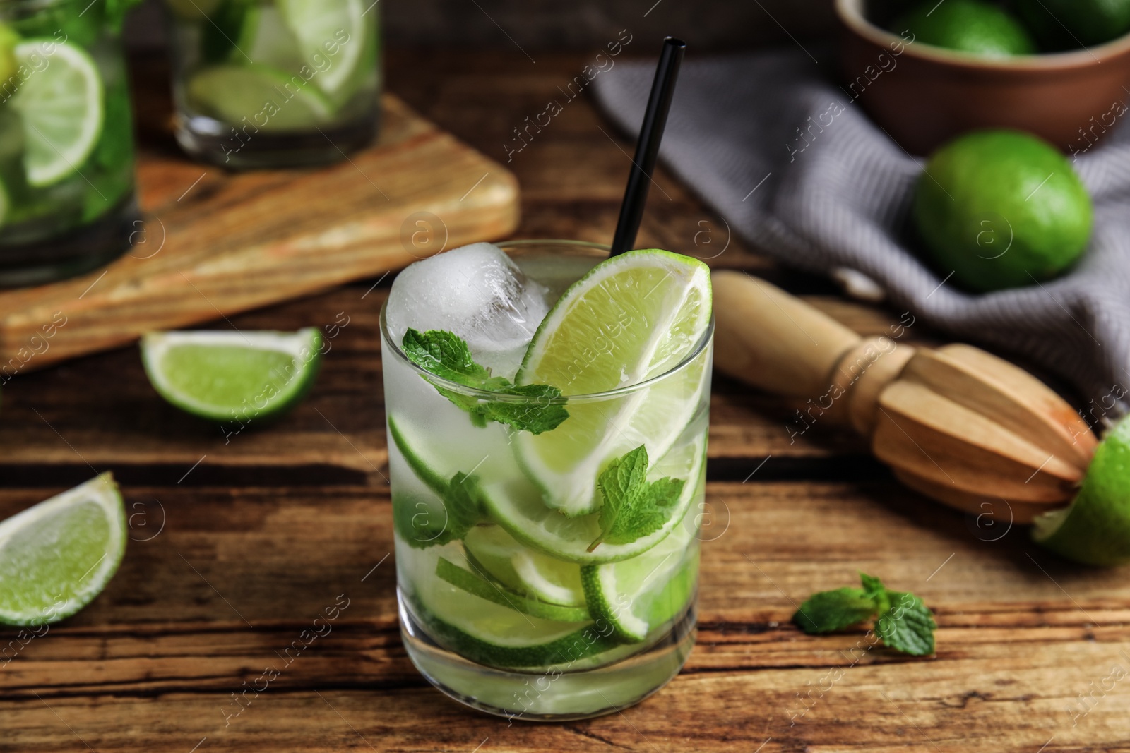 Photo of Delicious mojito and ingredients on wooden table