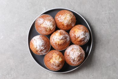 Photo of Delicious sweet muffins on light grey textured table, top view