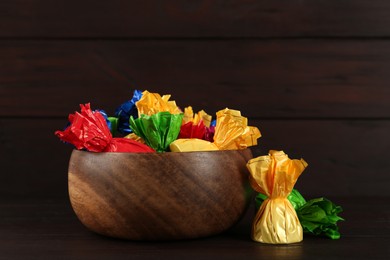 Candies in colorful wrappers on wooden table