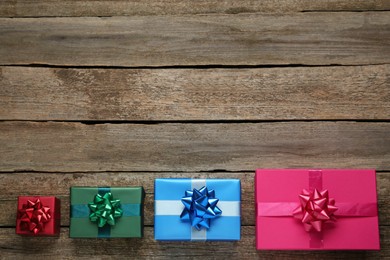Photo of Many colorful gift boxes on wooden table, flat lay. Space for text