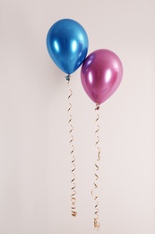 Photo of Color balloons with ribbons on white background