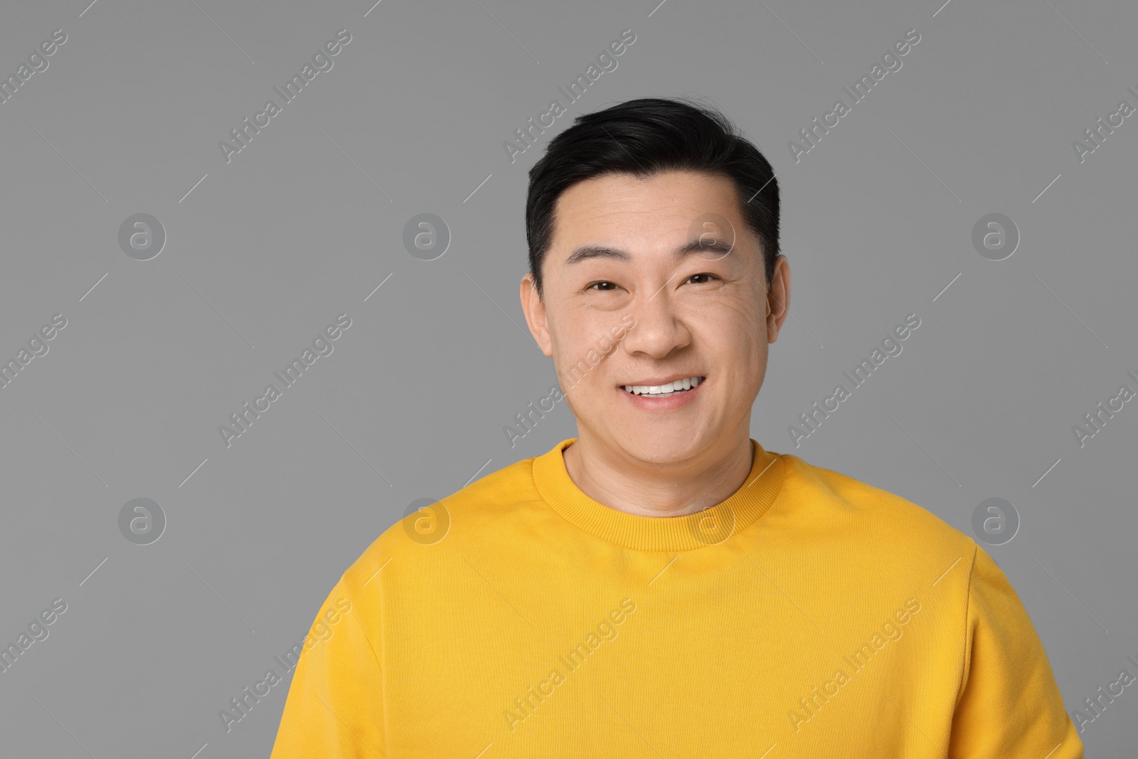 Photo of Portrait of happy man on grey background