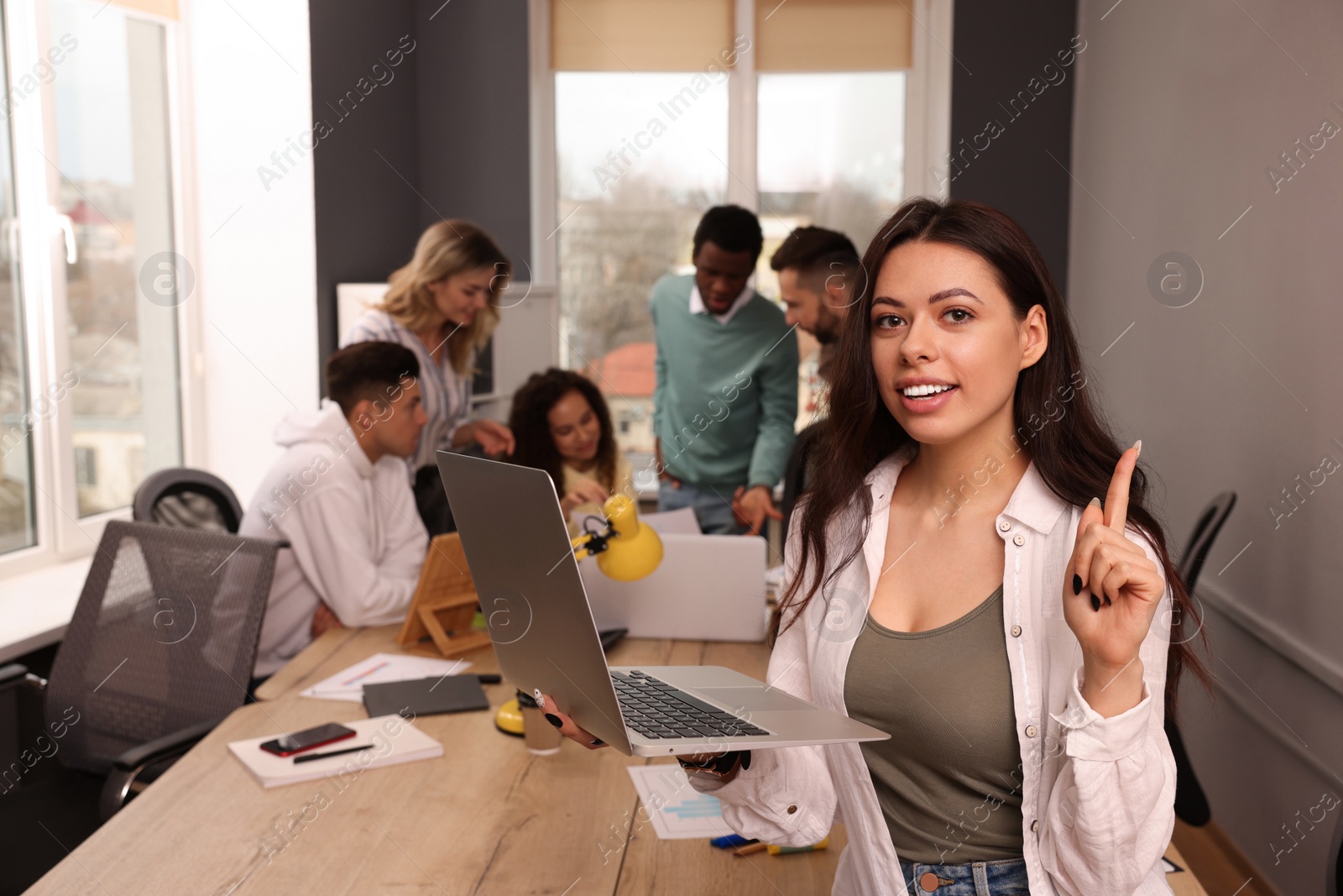 Photo of Portrait of happy young woman with laptop in office, space for text. Startup project