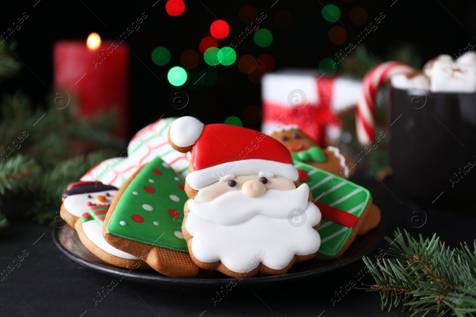 Photo of Delicious gingerbread Christmas cookies on black table, closeup