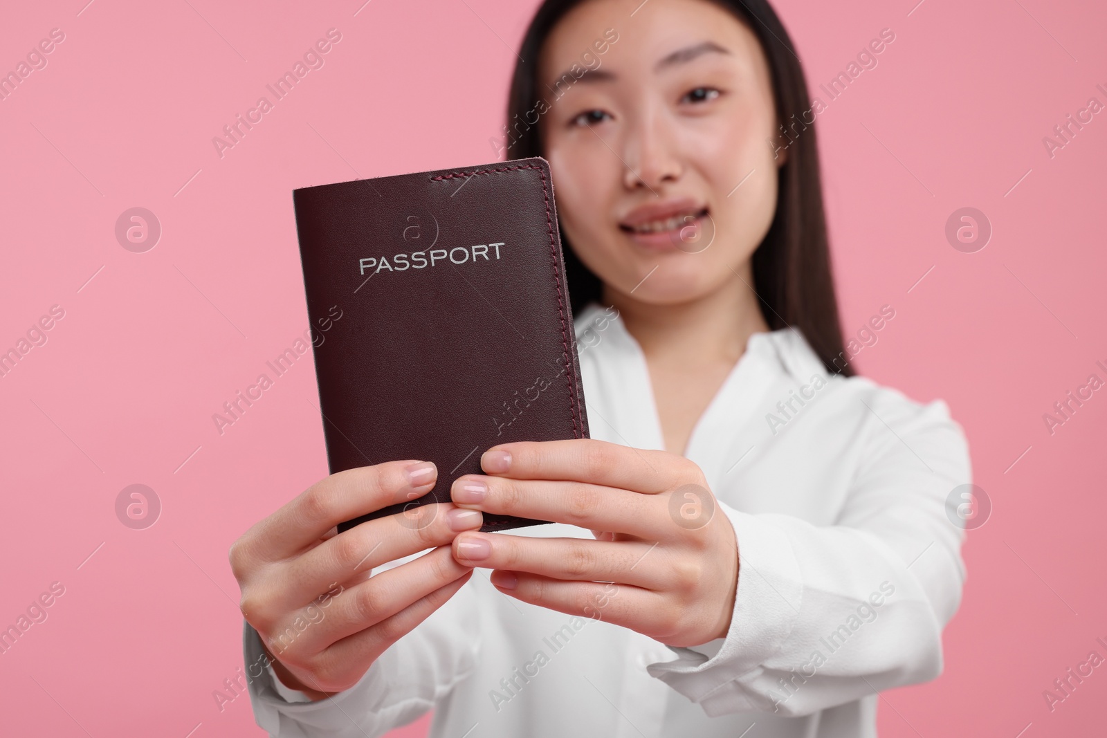 Photo of Immigration. Woman with passport on pink background, selective focus